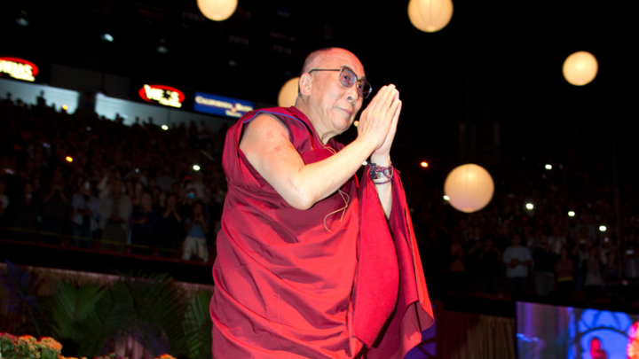 A person clasping their hands together standing over a carpet